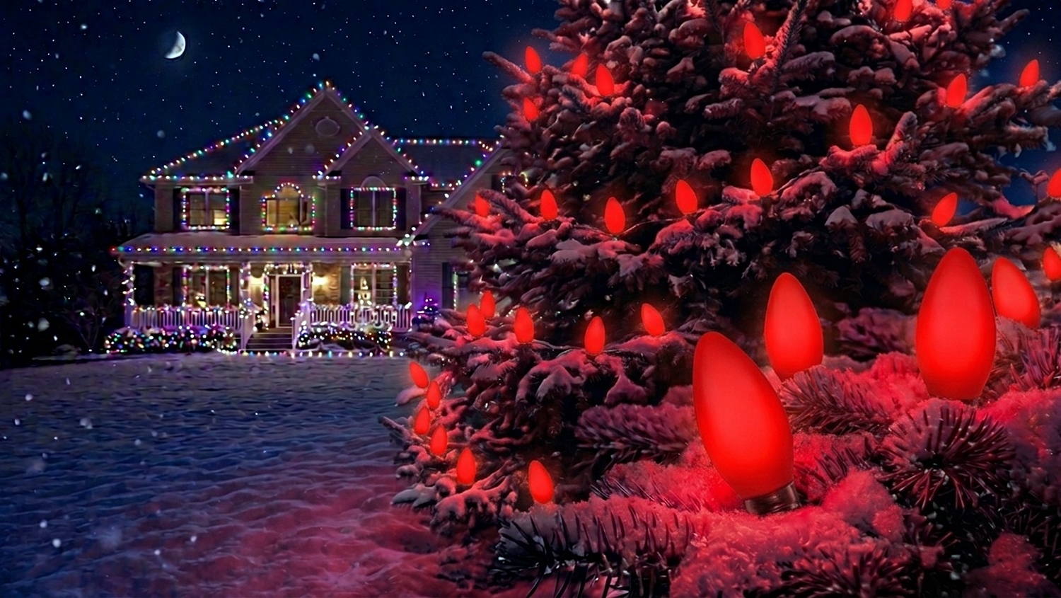 A large outdoor Christmas tree dusted in snow, lit up with glowing C9 Opaque Red bulbs with a lit-up house in the background.